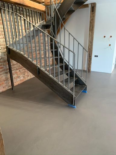 Mikrozement Boden Moderne Metalltreppe mit Holzgeländer in neuem, lichtdurchflutetem Raum.